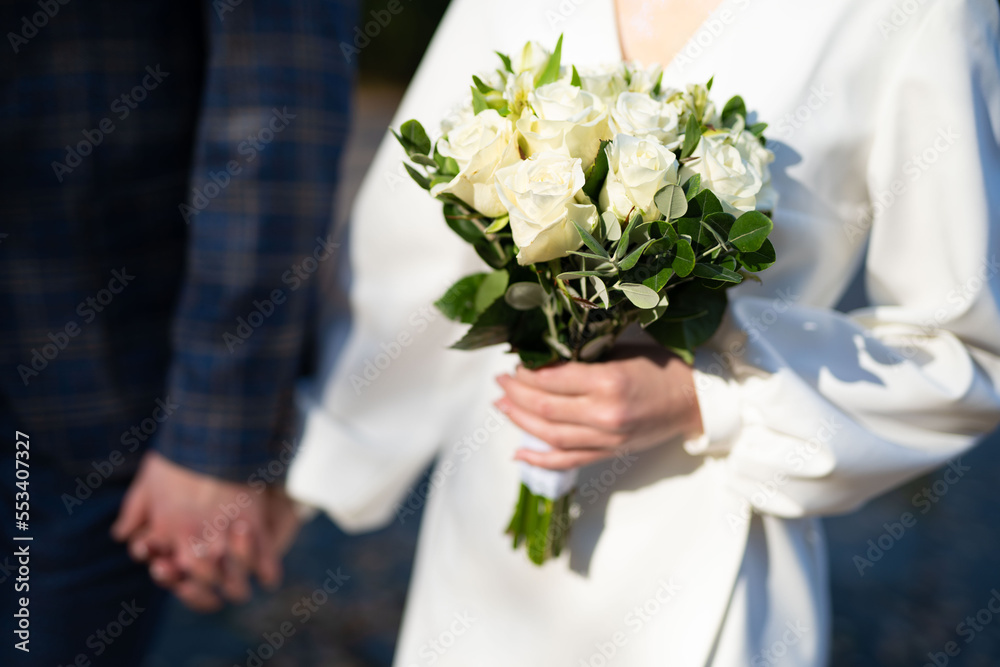 close-up of the wedding bouquet of the bride and groom, a couple in love holding hands together. close-up of the wedding bouquet of the bride and groom, a couple in love holding hands together.