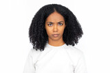 Displeased multiracial woman frowning. Portrait of confused young female model with dark curly hair in white T-shirt looking at camera with angry look. Anger, confusion concept