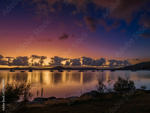 Aerial sunrise waterscape with boats, clouds and reflections