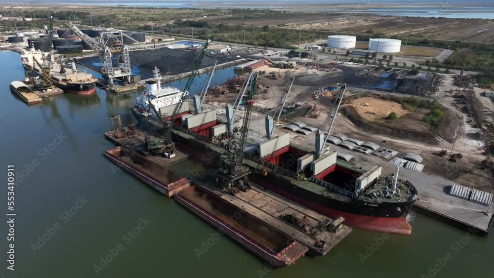 Cranes load cargo ships at Gulf Coast in Mobile Alabama. Deepwater port in Southern USA. Aerial view. Cranes load cargo ships at Gulf Coast in Mobile Alabama. Deepwater port in Southern USA. Aerial view.