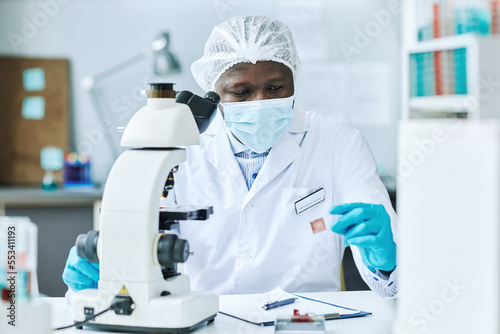 Portrait of black scientist doing blood tests in medical laboratory at clinic