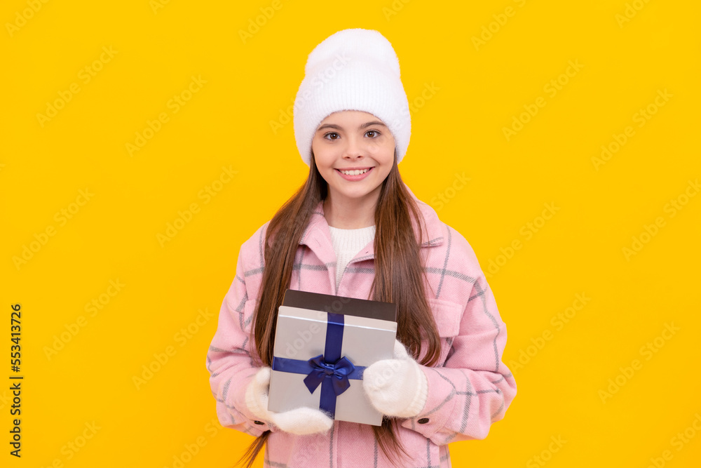 happy child in hat and mittens hold present box on yellow background, xmas happy child in hat and mittens hold present box on yellow background, xmas