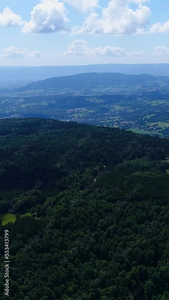 Vertical video of Aerial shot of a mountain with grass field, forest, countryside and lake Vertical video of Aerial shot of a mountain with grass field, forest, countryside and lake
