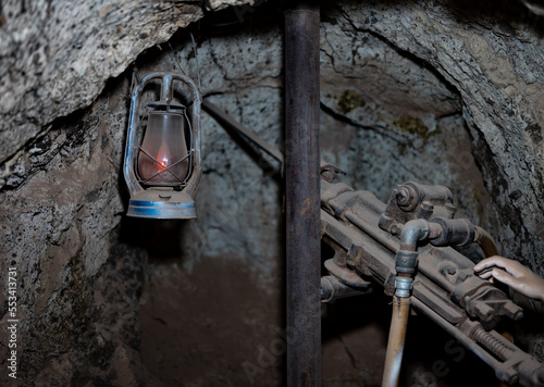 Detail of an abandoned gold mine excavation in the wild west, there is a prop, jackhammer and lamp