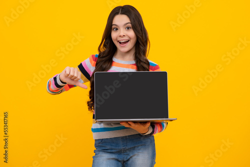 Young girl student hold computer. Funny pupil with laptop isolated on yellow background. Back to school. Screen of laptop computer with copy space mockup.