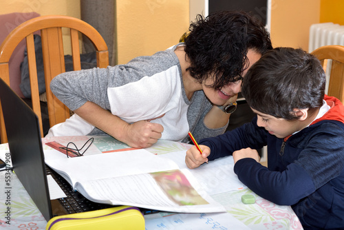 photograph of a young woman doing homework with her child. selective focus