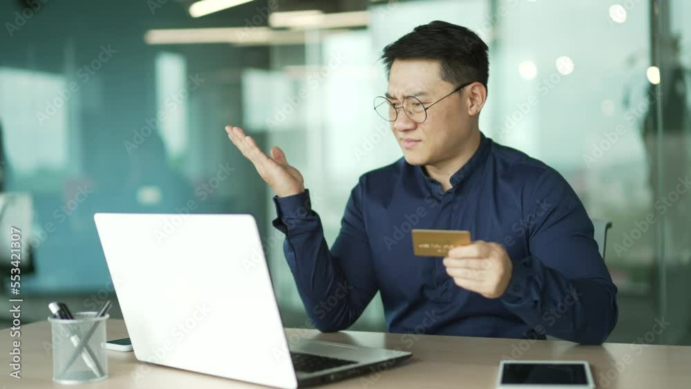 Nervous IT programmer with credit card has problem with online order bad service blocked bank account Stressed asian businessman doing internet shopping failure with money transfer payment on laptop Nervous IT programmer with credit card has problem with online order bad service blocked bank account Stressed asian businessman doing internet shopping failure with money transfer payment on laptop