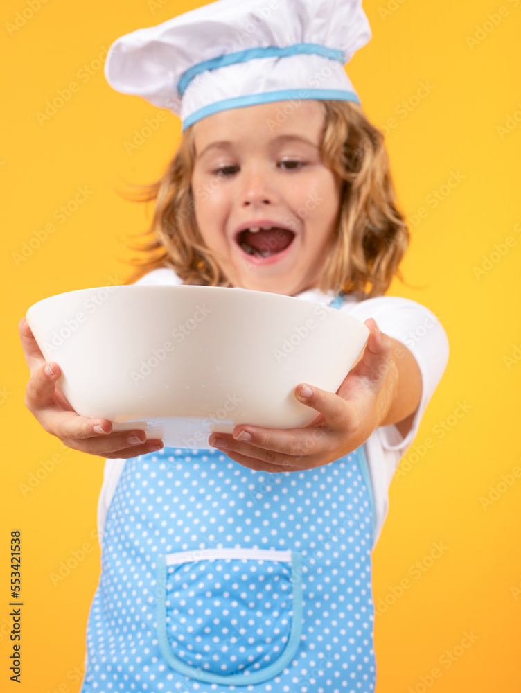 Funny kid chef cook with kitchen plate, studio portrait. Chef kid preparing healthy food. Portrait of child with chef hats. Funny kid chef cook with kitchen plate, studio portrait. Chef kid preparing healthy food. Portrait of child with chef hats.