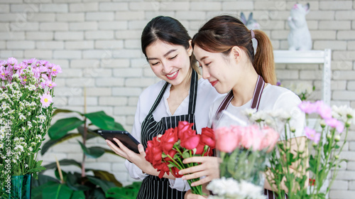 Billede på lærred Millennial Asian young professional flower shopkeeper florist employee worker we
