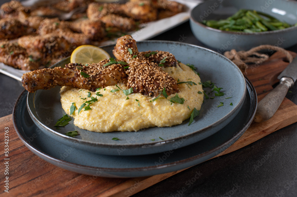 Chicken drumsticks with sesame seeds, polenta and green beans on a plate Chicken drumsticks with sesame seeds, polenta and green beans on a plate