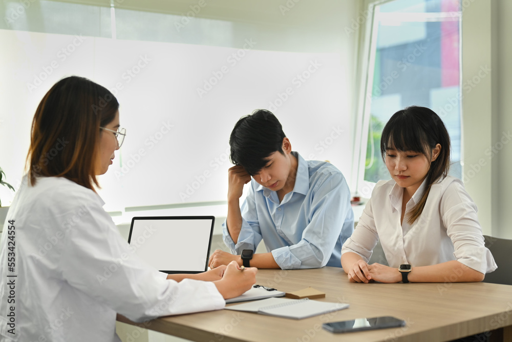 Side view of female gynecologist talking with infertile marriage about solution. Artificial insemination and family planning concept Side view of female gynecologist talking with infertile marriage about solution. Artificial insemination and family planning concept