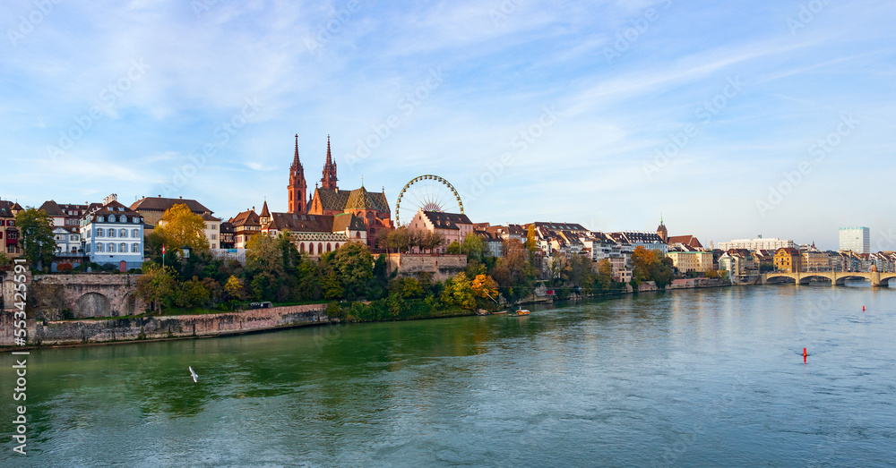 Obraz premium Panoramic view of the Basel embankment overlooking the Rhine and the silhouettes of the old buildings of the old town and the Ferris wheel of the autumn fair Herbstmesse 