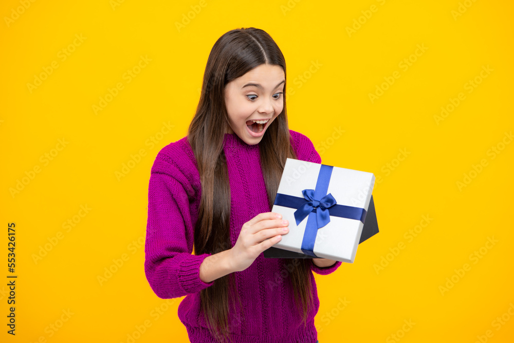 Surprised emotions of young teenager girl. Child teen girl 12-14 years old with gift on isolated background. Birthday, holiday concept. Teenager hold present box. Surprised emotions of young teenager girl. Child teen girl 12-14 years old with gift on isolated background. Birthday, holiday concept. Teenager hold present box.