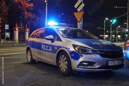 Aresztowanie przez policji wieczorem w mieście. - Sygnalizator błyskowy niebieski na dachu radiowozu policji polskiej w nocy. 