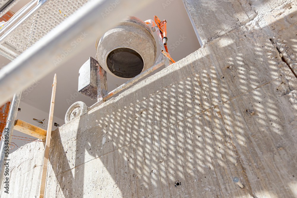 Εκτύπωση καμβά Bottom shot on mortar mixer machine on the terrace of unfinished edifice with sc