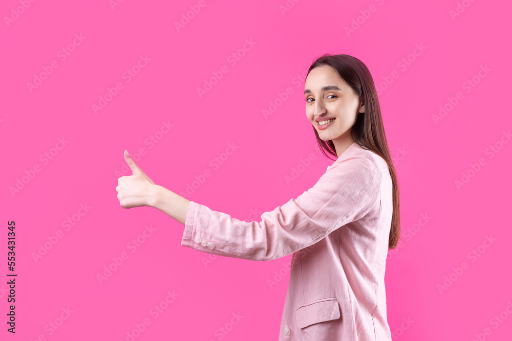 Happy young caucasian female in an pink jacket making thumb up sign and smiling. Good job and respect. Happy young caucasian female in an pink jacket making thumb up sign and smiling. Good job and respect.