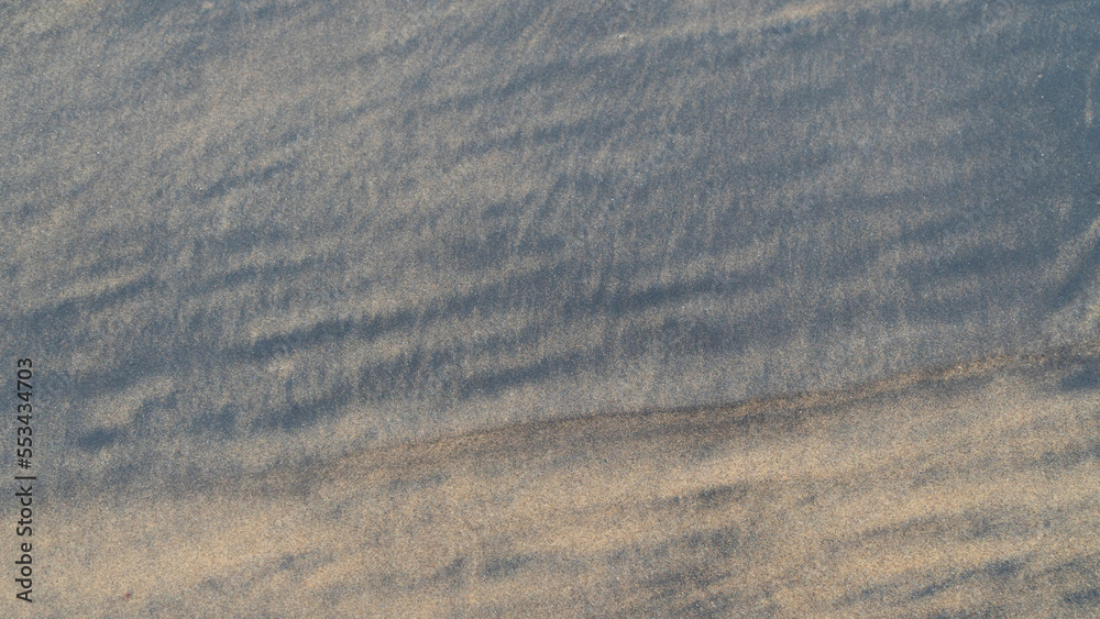 Fototapeta premium Black and brown sea sand close-up background