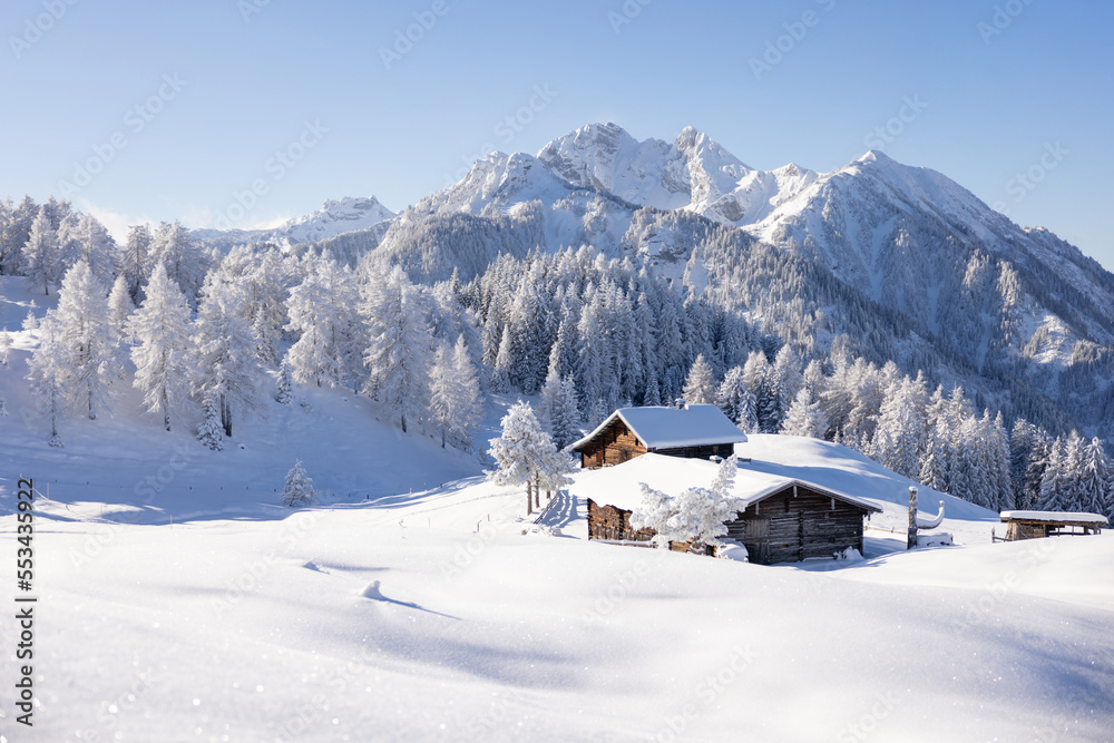 Traditional wooden house in the Alps covered with snow.