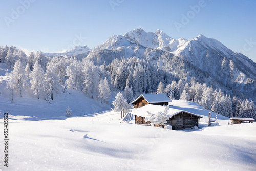 Traditional wooden house in the Alps covered with snow.