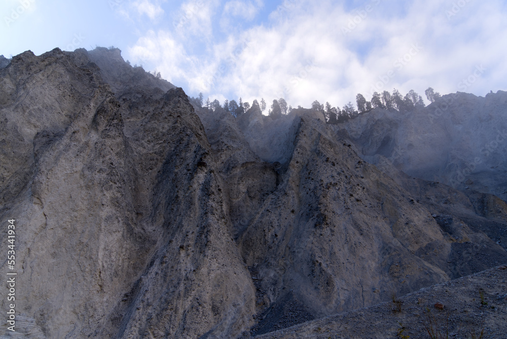 Cliff with cone of debris at canyon of Anterior Rhine Valley on a blue cloudy autumn morning at Versam, Canton Graubünden. Photo taken September 26th, 2022, Versam, Anterior Rhein valley, Switzerland.