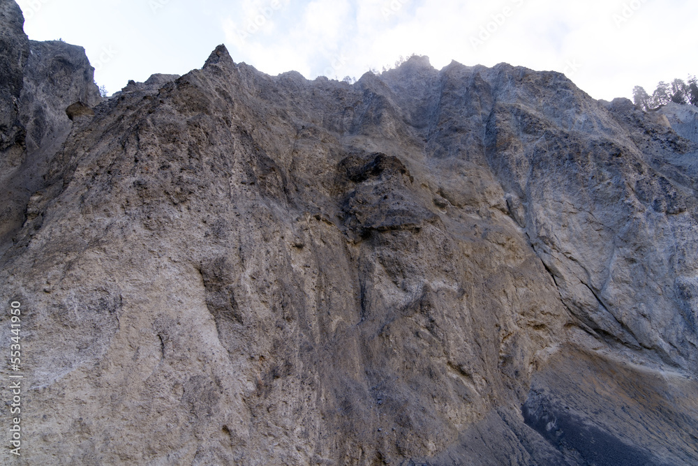 Cliff with cone of debris at canyon of Anterior Rhine Valley on a blue cloudy autumn morning at Versam, Canton Graubünden. Photo taken September 26th, 2022, Versam, Anterior Rhein valley, Switzerland.