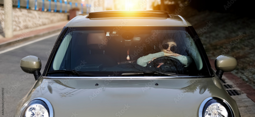 Asian girl meditating on the steering wheel