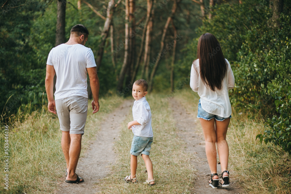 Happy young family father, mother and little son having fun outdoors, playing together in park Happy young family father, mother and little son having fun outdoors, playing together in park