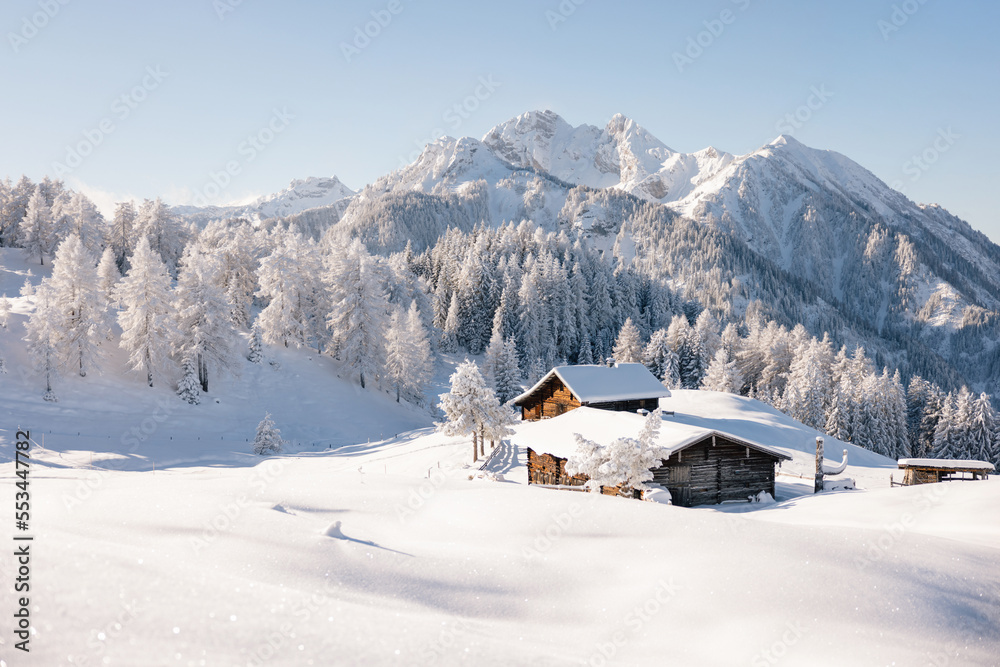 Beautiful winter mountain landscape with snowcapped wooden hut