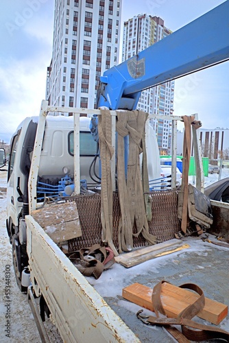 A fragment of a snow-covered truck with a manipulator on a winter day