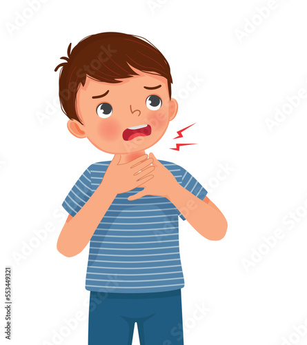 cute little boy suffering from sore throat touching his swelling and painful neck as symptoms of flu and allergy
