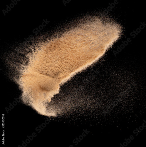 Small size fine Sand flying explosion, Golden grain wave explode. Abstract cloud fly. Yellow colored sand splash silica in Air. Black background Isolated high speed shutter, throwing freeze shot