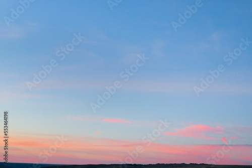 Minimal artistic colorful sunrise sky background with orange and pink colors on horizon line.