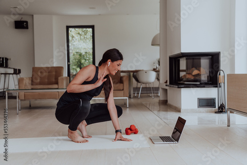 Young Beautiful Female Woman with Trainer via Video Call Conference in Bright Sunny House. Healthy Lifestyle, Wellbeing and Mindfulness Concept.
