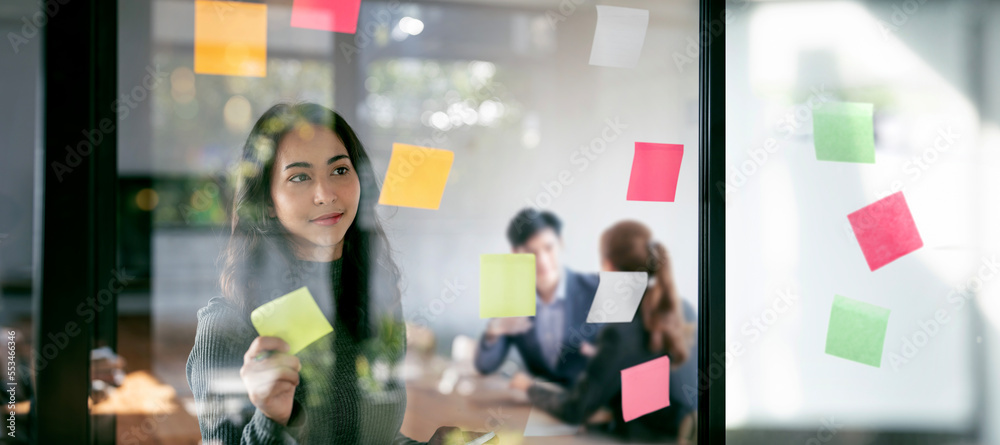 Young confident Businesswoman planning with adhesive notes in creative office. - obrazy, fototapety, plakaty 