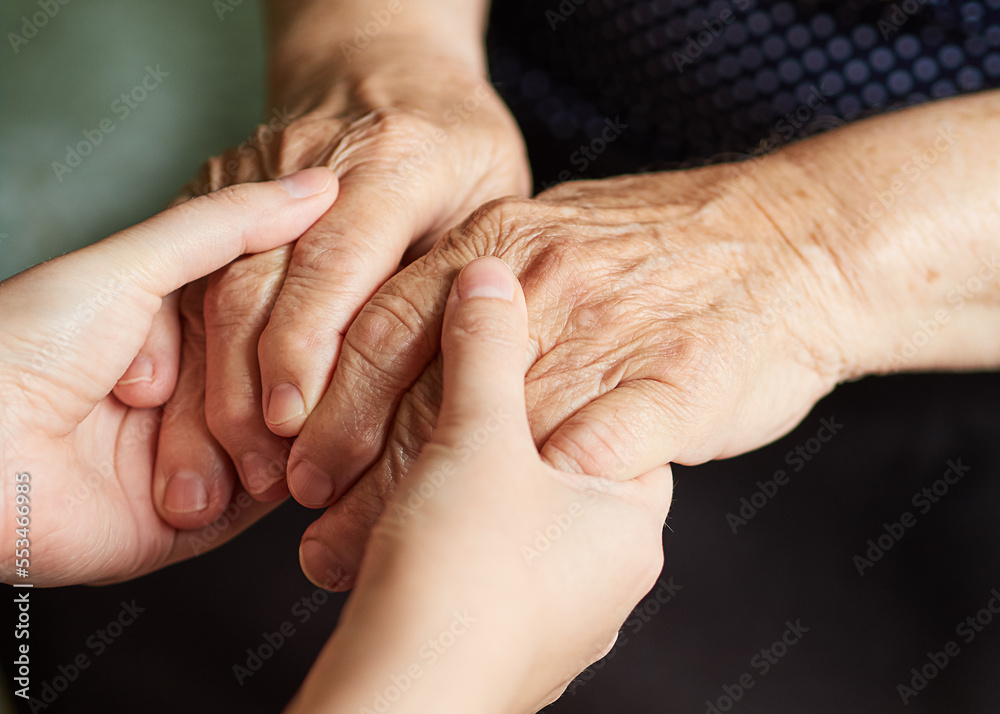 Young hands hold old hands on a dark background. Young hands hold old hands on a dark background.
