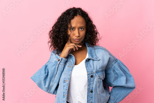 Teenager cuban girl isolated on pink background and thinking