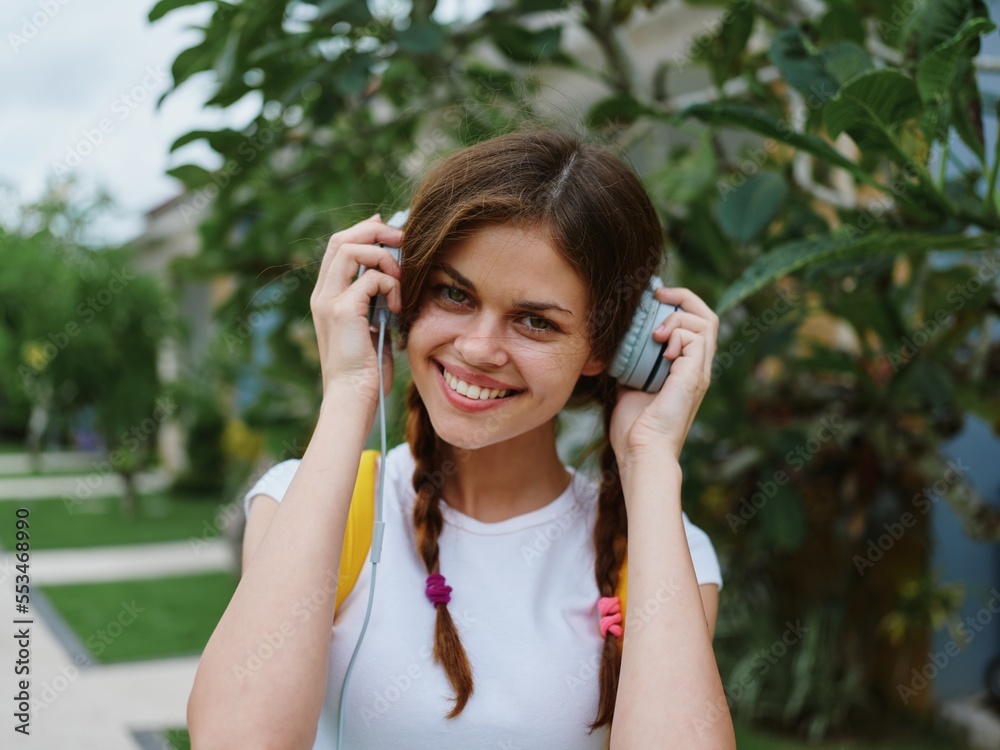 Woman student happiness travels with a backpack and headphones listening to music with a smile Woman student happiness travels with a backpack and headphones listening to music with a smile