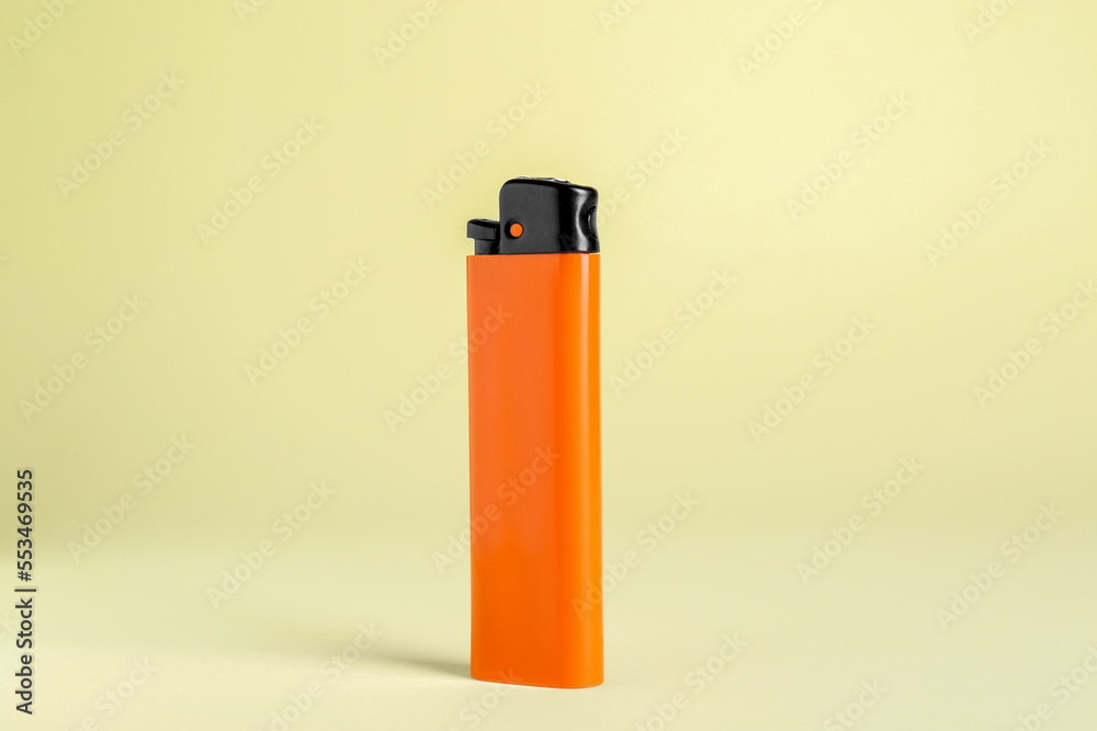 Stylish small pocket lighter on beige background Stylish small pocket lighter on beige background