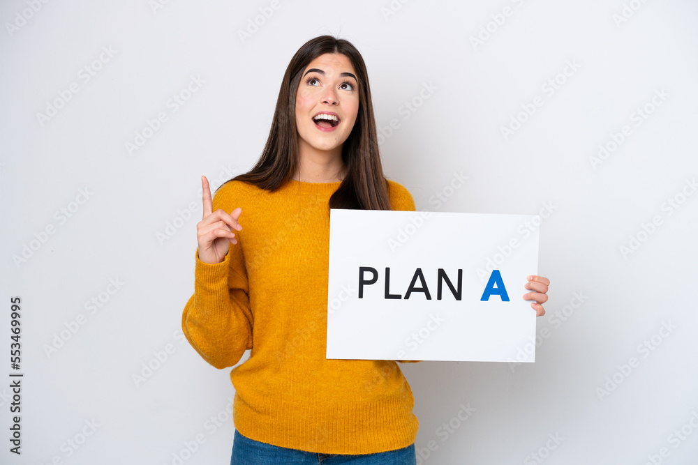 Young Brazilian woman isolated on white background holding a placard with the message PLAN A and thinking Young Brazilian woman isolated on white background holding a placard with the message PLAN A and thinking