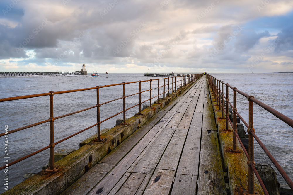 Obraz premium Wooden South Pier at Blyth Harbour, which lies about 7 miles north of Tynemouth and has had a very commercial recent past. It sits on the east coast of Northumberland in England