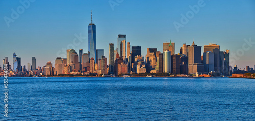 New York City southern Manhattan panoramic skyline near sunset golden hour dusk from bay with One World Observatory