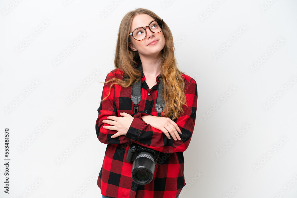 Naklejka premium Young photographer pretty woman isolated on white background looking up while smiling