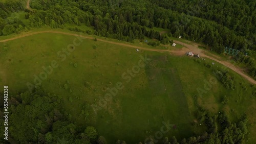 Aerial view of the Colorful landscape with green meadows and dirt road in Carpathian Mountains. Top view of mountain countryside. Kolochava pass, Transcarpathian, Ukraine photo