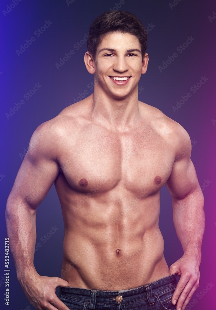 Fototapeta premium Sportive young male bodybuilder in neon light