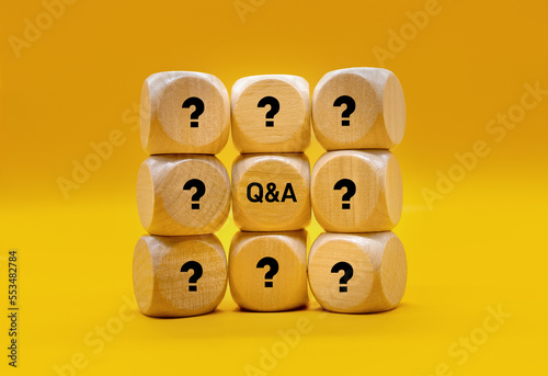 Wooden block with Q and A characters. The symmetrical surface of the table reflects the Q and A captions