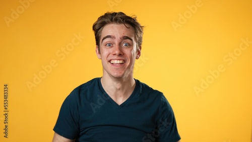 Portrait of amazed young man 20s shocked, saying WOW. Handsome guy surprised isolated on solid yellow background.