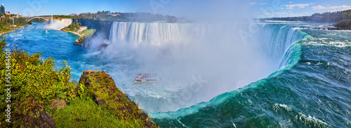 Wide panorama on edge of Horseshoe Falls showcasing size and misty falls with tourist ship