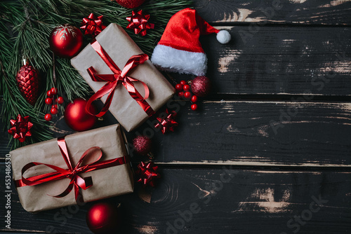 Christmass background gift boxes,red christmas tree toys,Santa hatn and spruce brance on wooden background. photo