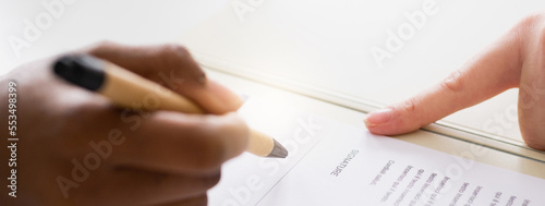 Close-up unrecognizable woman hand signing a contract. Horizontal banner or header. Agreement concept.