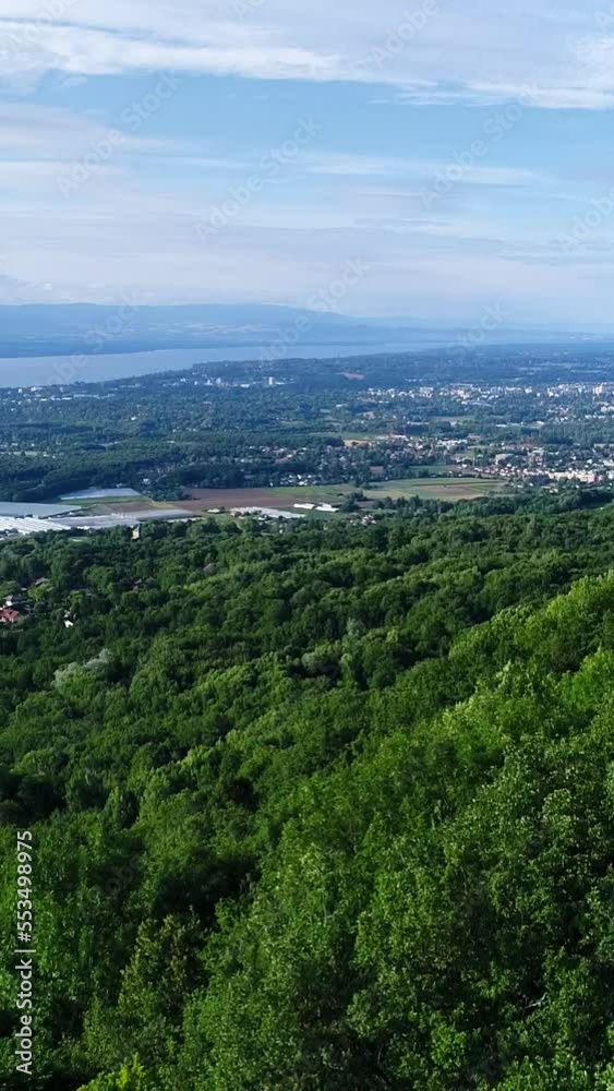 Vertical video of Aerial shot of countryside with lake next to forest side of mountain Vertical video of Aerial shot of countryside with lake next to forest side of mountain
